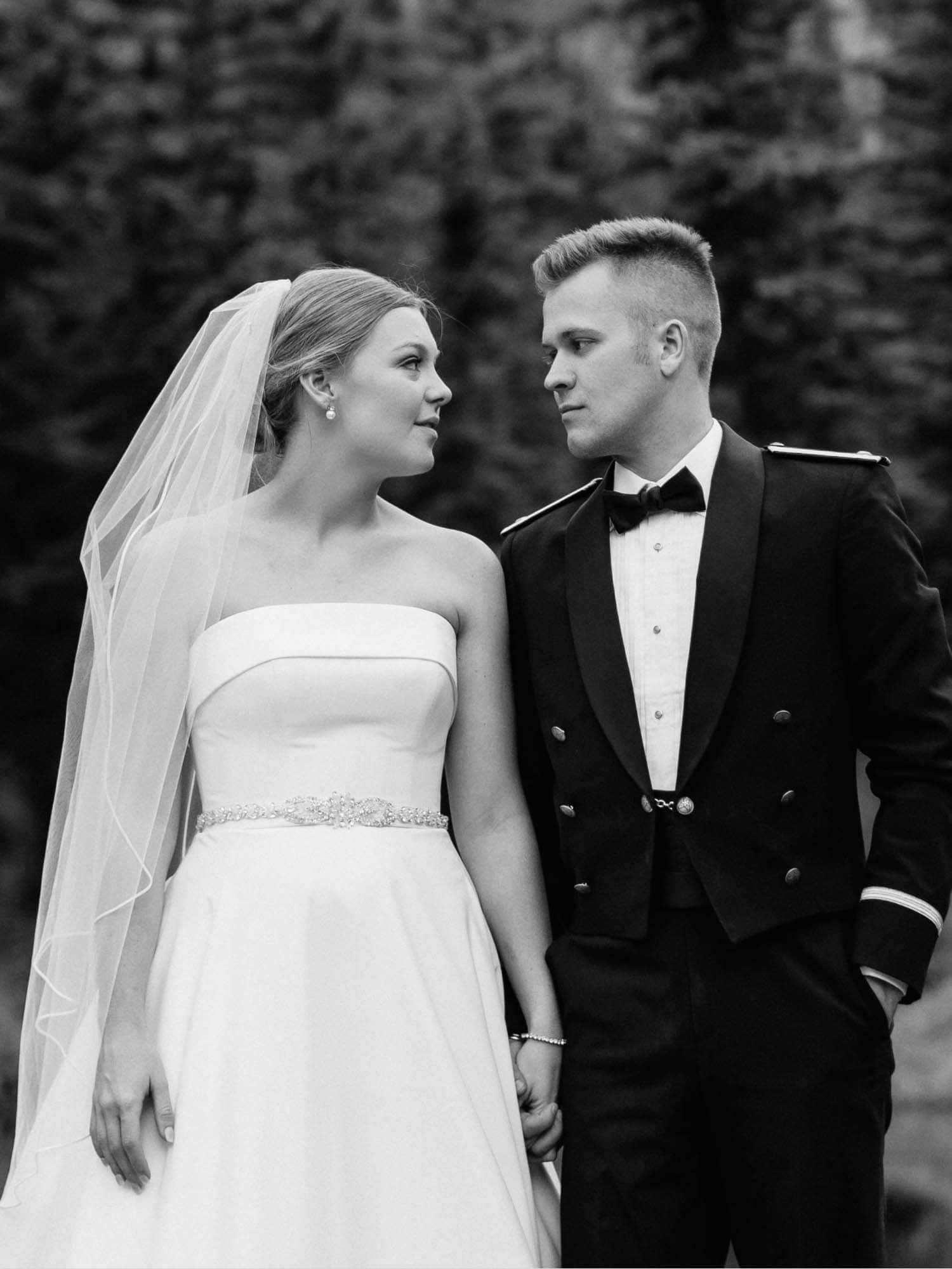 Сouple wearing a white gown and a black suit. Mobile image