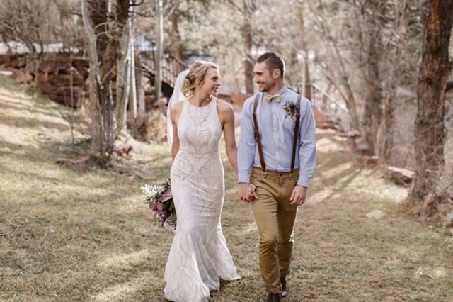 Сouple wearing a white gown and a light suit on the grass